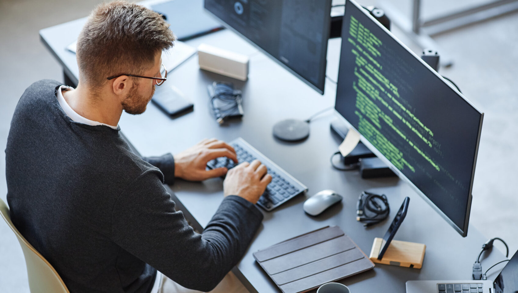 High angle view at software developer writing code while using computer and data systems in office